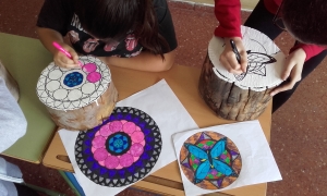 Alumnas dibujando mandalas en los troncos